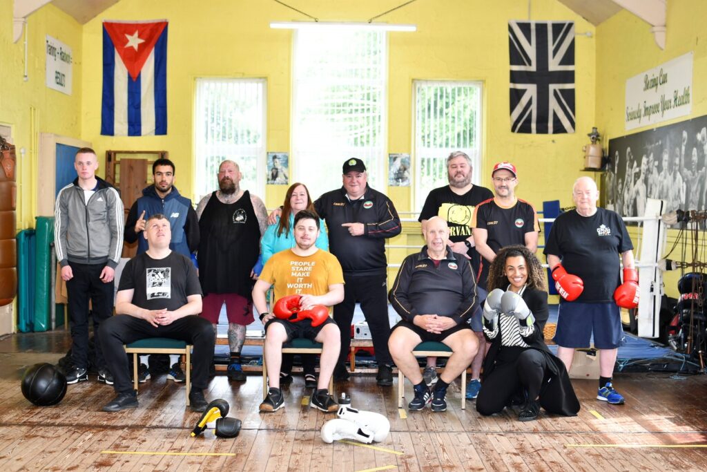 Coaches and members of the Empire School of Boxing with (front, right) Jamilah Hassan of the Banks Group